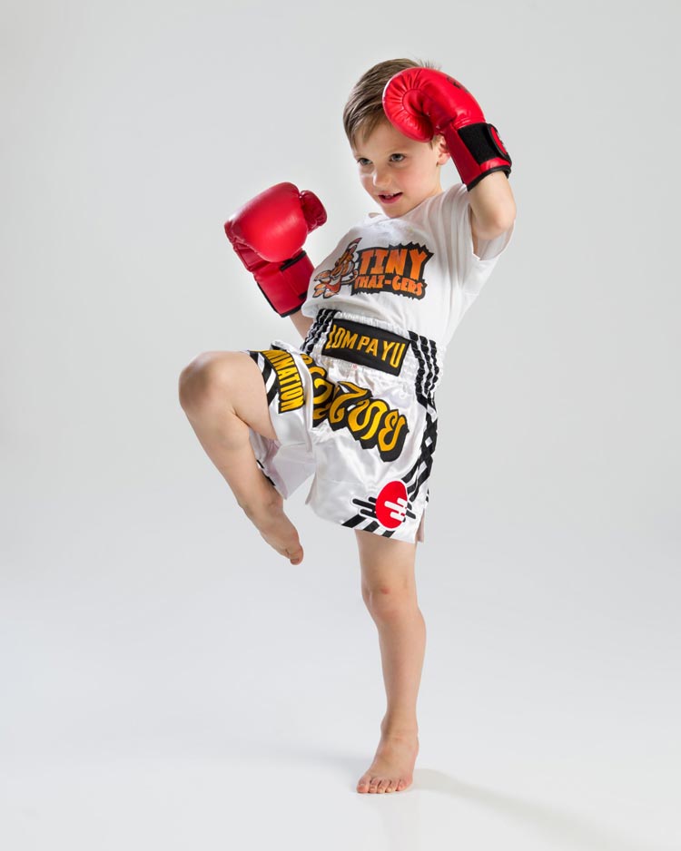 Young Arashi-Do Tiny Thaigers student in branded Lom Pa Yu kit practicing a knee strike