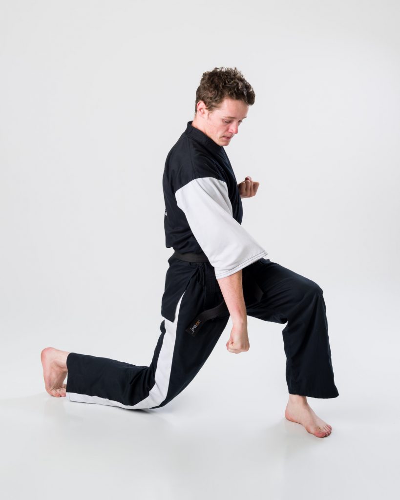 Adult black-belt karate student practicing a reverse punch at Arashi-Do Red Deer